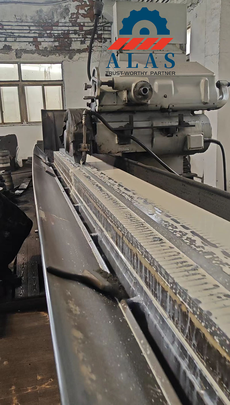 ALAS Machining Infrastructure: Precision Long-Bed Grinding Machine 平面磨床在 ALAS 上用冷却液精密磨削长剪切刀片。